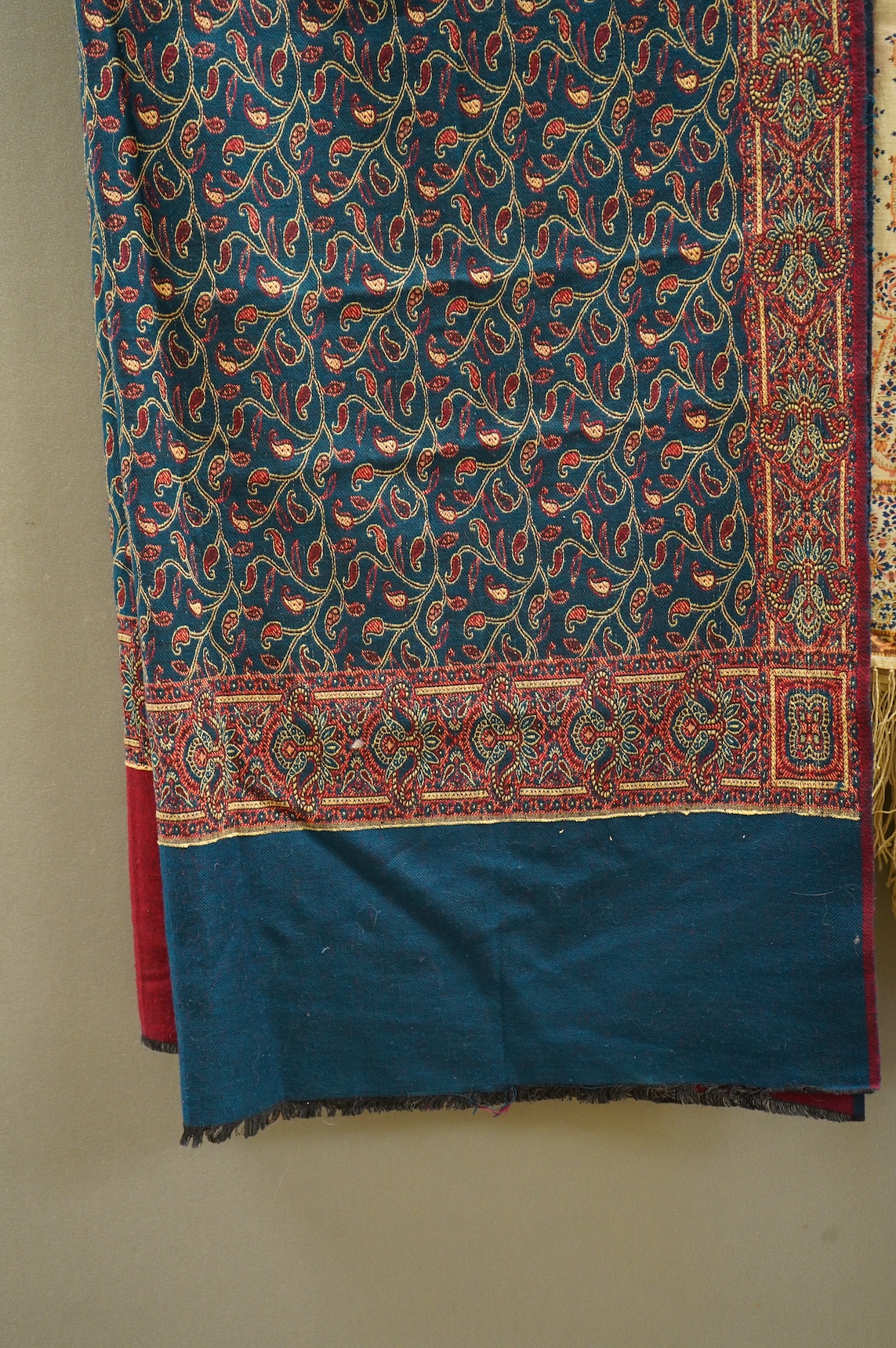 A 19th century printed silk shawl and a printed paisley shawl, together with a late 20th century wool machine woven stole with Oswal label. Condition - the two 19th century shawls are damaged but useful for TV and film c